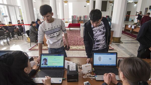 Избиратели проходят процедуру подтверждения личности с помощью сканирования отпечатка пальца на избирательном участке в Бишкеке, перед тем как проголосовать на выборах президента Киргизии Избиратели проходят процедуру подтверждения личности с помощью сканирования отпечатка пальца на избирательном участке в Бишкеке, перед тем как проголосовать на выборах президента Киргизии