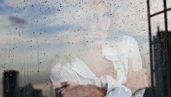 Девушка у окна во время дождя. Архивное фото Девушка у окна во время дождя. Архивное фото