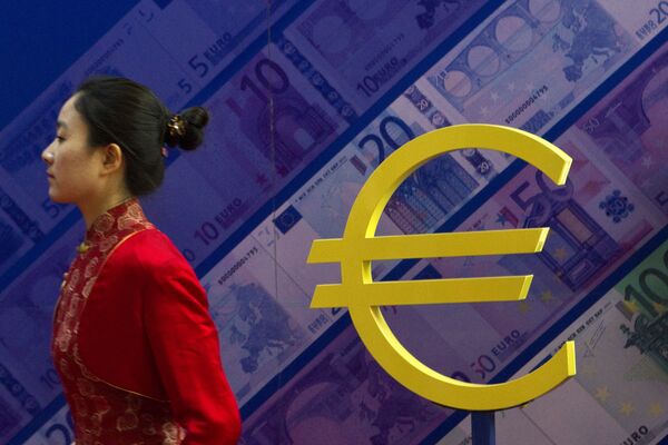 Девушка проходит мимо знака евро на выставке, посвященной валюте в Пекине Девушка проходит мимо знака евро на выставке, посвященной валюте в Пекине