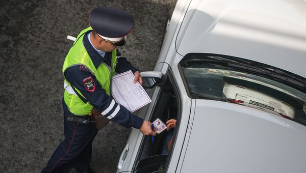 Сотрудник ГИБДД проверяет документы Сотрудник ГИБДД проверяет документы