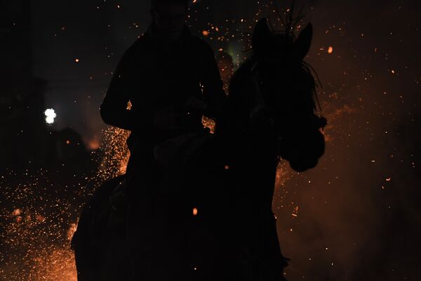 Всадник прыгает через костер во время огненного фестиваля Las Luminarias в Испании Всадник прыгает через костер во время огненного фестиваля Las Luminarias в Испании