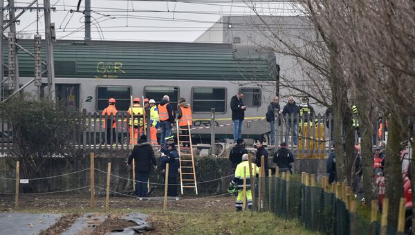 Спасатели и полицейские на месте крушения поезда на окраине Милана, Италия. 25 января 2018 года Спасатели и полицейские на месте крушения поезда на окраине Милана, Италия. 25 января 2018 года