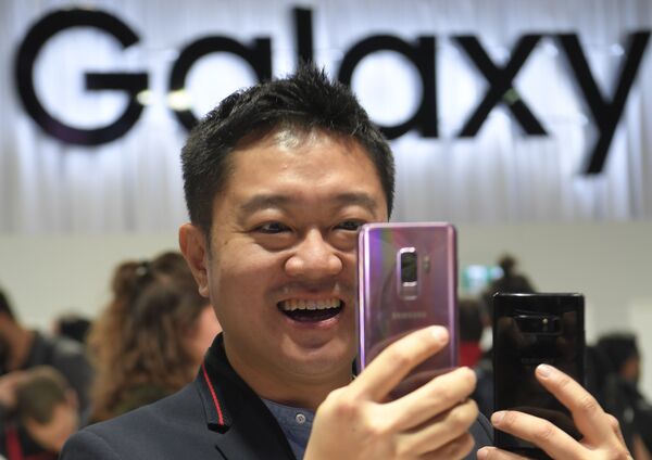 Мужчина держит новый Samsung Galaxy S9 на мероприятии Samsung Galaxy Unpacked 2018 в Барселоне, Испания. 25 февраля 2018 года Мужчина держит новый Samsung Galaxy S9 на мероприятии Samsung Galaxy Unpacked 2018 в Барселоне, Испания. 25 февраля 2018 года