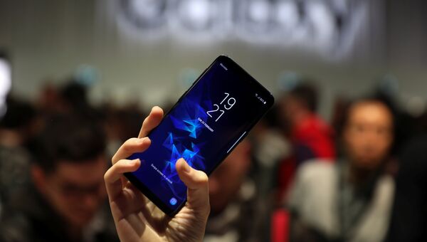 Девушка держит новый смартфон Samsung Galaxy S9 после презентации Mobile World Congress в Барселоне, Испания. 25 февраля 2018 года Девушка держит новый смартфон Samsung Galaxy S9 после презентации Mobile World Congress в Барселоне, Испания. 25 февраля 2018 года