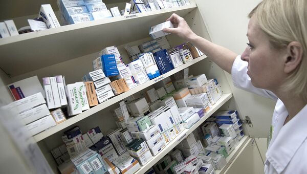Сотрудница аптеки разбирает лекарства Сотрудница аптеки разбирает лекарства