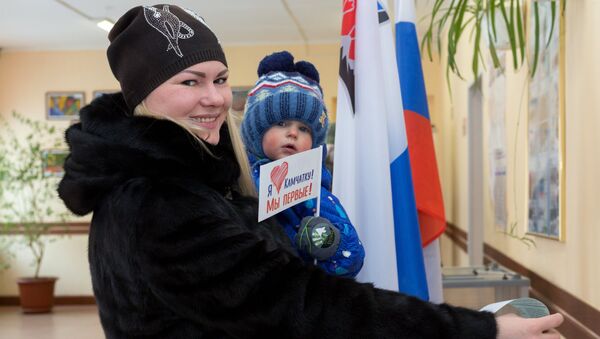 Женщина опускает бюллетень в урну на выборах президента РФ на избирательном участке №51 в Петропавловске-Камчатском. Женщина опускает бюллетень в урну на выборах президента РФ на избирательном участке №51 в Петропавловске-Камчатском.