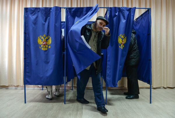 Мужчина выходит из кабинки во время голосования на выборах президента Российской Федерации на избирательном участке в Новосибирске. 18 марта 2018 Мужчина выходит из кабинки во время голосования на выборах президента Российской Федерации на избирательном участке в Новосибирске. 18 марта 2018