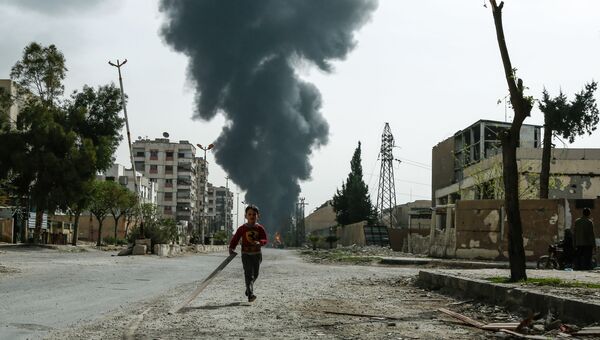 Мальчик бежит по улице в Сирии. Архивное фото Мальчик бежит по улице в Сирии. Архивное фото