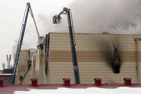 Сотрудники пожарной охраны МЧС борются с пожаром в торговом центре «Зимняя вишня» в Кемерово. 25 марта 2018 Сотрудники пожарной охраны МЧС борются с пожаром в торговом центре «Зимняя вишня» в Кемерово. 25 марта 2018