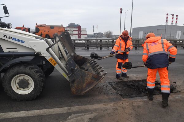 Рабочие ремонтируют участок дороги в Москве