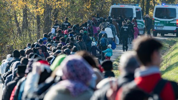 Мигранты в сопровождении полиции Германии направляются в центр экстренной помощи после пересечения австрийско-германской границы. 27 октября 2015 Мигранты в сопровождении полиции Германии направляются в центр экстренной помощи после пересечения австрийско-германской границы. 27 октября 2015