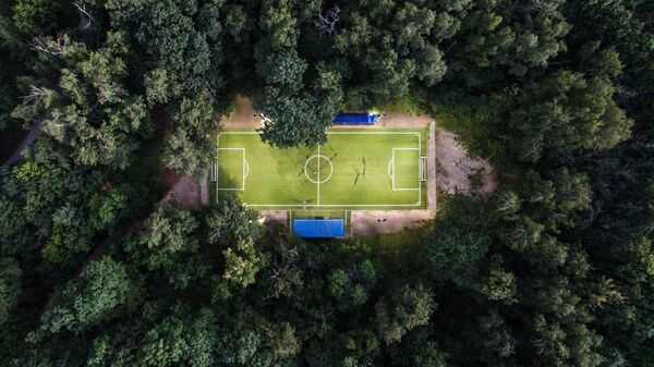 Люди играют в футбол в Нескучном саду в Москве Люди играют в футбол в Нескучном саду в Москве