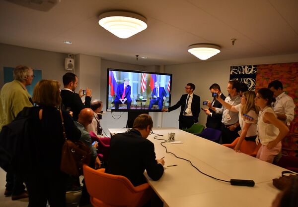 Журналисты смотрят трансляцию встречи президента РФ Владимира Путина и президента США Дональда Трампа в Хельсинки. 16 июля 2018 Журналисты смотрят трансляцию встречи президента РФ Владимира Путина и президента США Дональда Трампа в Хельсинки. 16 июля 2018