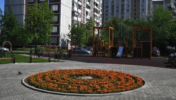 Детская игровая площадка и цветочная клумба во дворе дома в Москве Детская игровая площадка и цветочная клумба во дворе дома в Москве