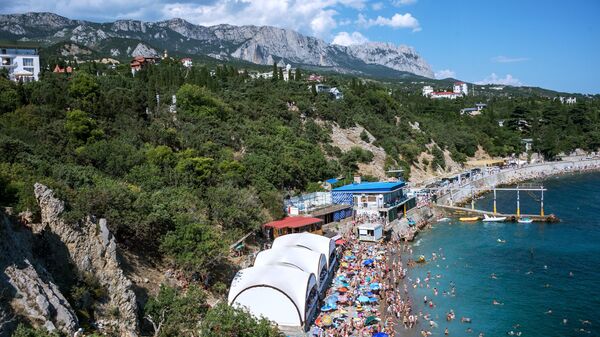 Отдыхающие на пляже курортного поселка Симеиз в Крыму Отдыхающие на пляже курортного поселка Симеиз в Крыму