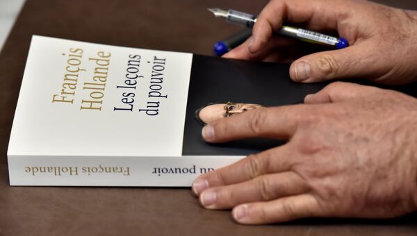 Книга о презендентском сроке Франсуа Олланда в его руках Книга о презендентском сроке Франсуа Олланда в его руках