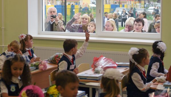 Родители в окне средней общеобразовательной школы во время первого занятия Родители в окне средней общеобразовательной школы во время первого занятия