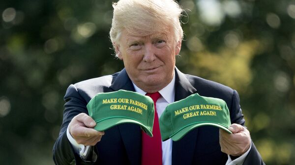 Президент США Дональд Трамп демонстрирует кепки с надписью Сделаем наших фермеров снова великими. Вашингтон, США 