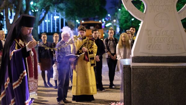 Священнослужитель читает молебен у импровизированного мемориала в Краснодаре в память о погибших при нападении на керченский колледж Священнослужитель читает молебен у импровизированного мемориала в Краснодаре в память о погибших при нападении на керченский колледж