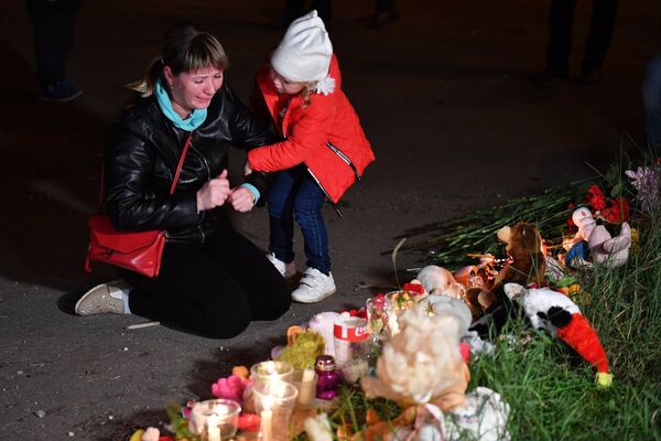 Женщина у народного мемориала на улице в Керчи, где в Керченском политехническом колледже произошли взрыв и стрельба Женщина у народного мемориала на улице в Керчи, где в Керченском политехническом колледже произошли взрыв и стрельба