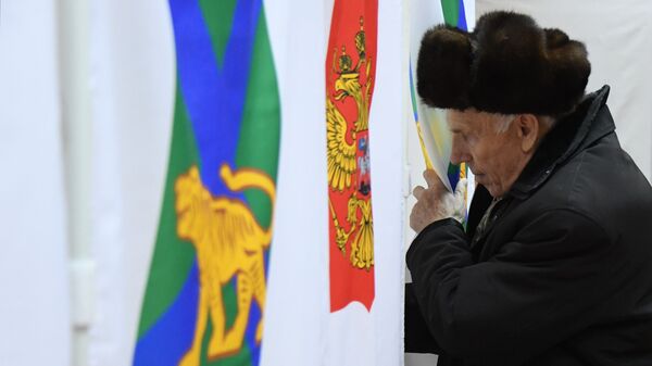 Мужчина голосует на повторных выборах губернатора Приморского края на избирательном участке во Владивостоке. 16 декабря 2018 Мужчина голосует на повторных выборах губернатора Приморского края на избирательном участке во Владивостоке. 16 декабря 2018