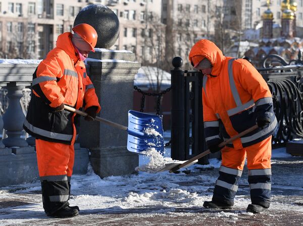 Сотрудники коммунальных служб убирают снег Сотрудники коммунальных служб убирают снег