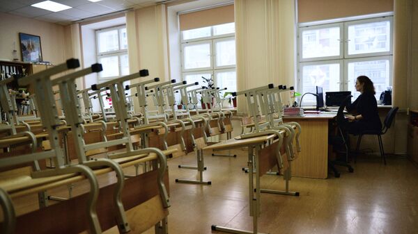 Преподаватель в пустом учебном классе школы. Архивное фото Преподаватель в пустом учебном классе школы. Архивное фото