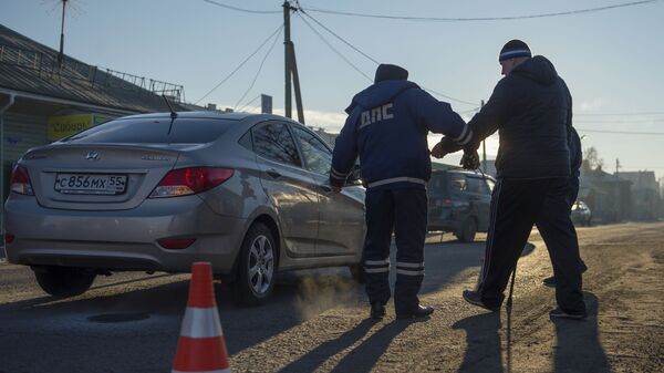 Сотрудник дорожно-патрульной службы ГИБДД на месте дорожно-транспортного происшествия Сотрудник дорожно-патрульной службы ГИБДД на месте дорожно-транспортного происшествия