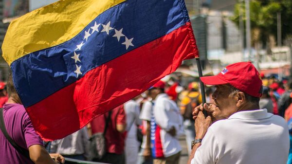 Мужчина с флагом Венесуэлы в Каракасе