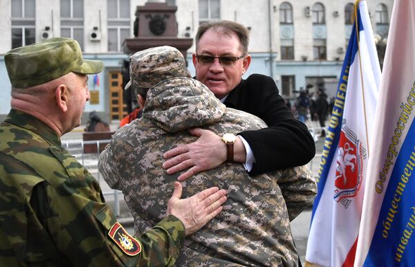 Люди поздравляют друг друга с 5-й годовщиной Общекрымского референдума 2014 года и воссоединения Крыма с Россией на одной из улиц в Симферополе Люди поздравляют друг друга с 5-й годовщиной Общекрымского референдума 2014 года и воссоединения Крыма с Россией на одной из улиц в Симферополе