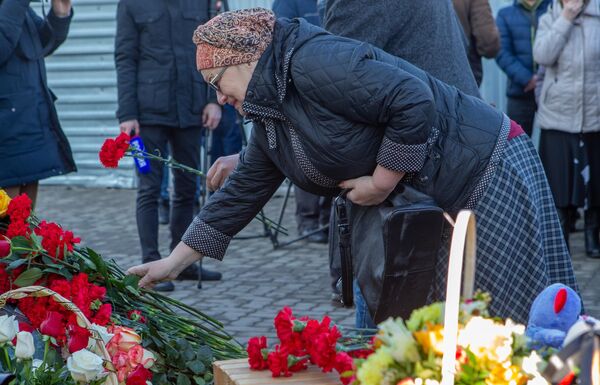 Женщина возлагает цветы к мемориалу в память о жертвах пожара в торгово-развлекательном центре Зимняя вишня в Кемерово Женщина возлагает цветы к мемориалу в память о жертвах пожара в торгово-развлекательном центре Зимняя вишня в Кемерово