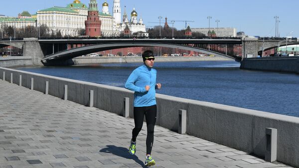 Мужчина бежит по Пречистенской набережной в Москве Мужчина бежит по Пречистенской набережной в Москве