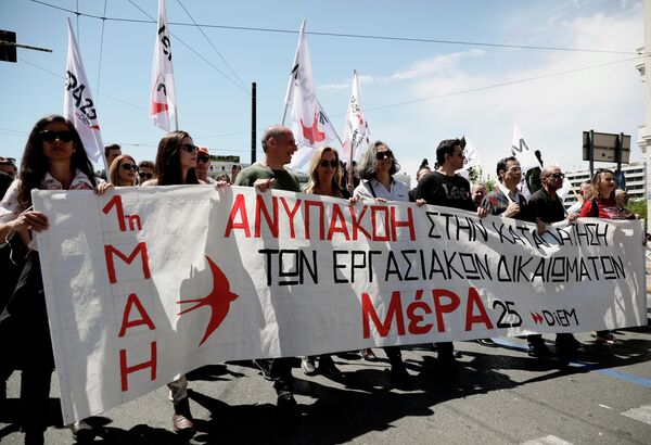 Участники первомайской демонстрации в Афинах, протестующие против экономической политики правительства и выступающие за реализацию прав трудящихся на достойную зарплату и социальную защиту Участники первомайской демонстрации в Афинах, протестующие против экономической политики правительства и выступающие за реализацию прав трудящихся на достойную зарплату и социальную защиту
