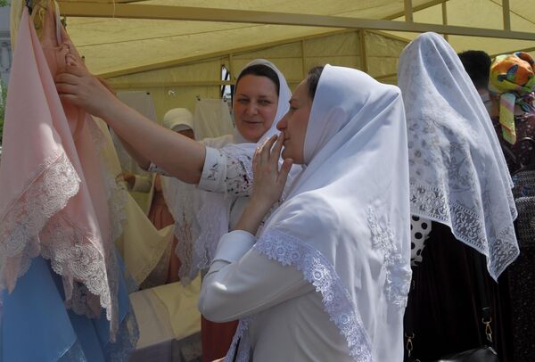 Женщина выбирает платок в день праздника Святых Жён-Мироносиц в духовном центре старообрядчества Рогожская слобода в Москве Женщина выбирает платок в день праздника Святых Жён-Мироносиц в духовном центре старообрядчества Рогожская слобода в Москве