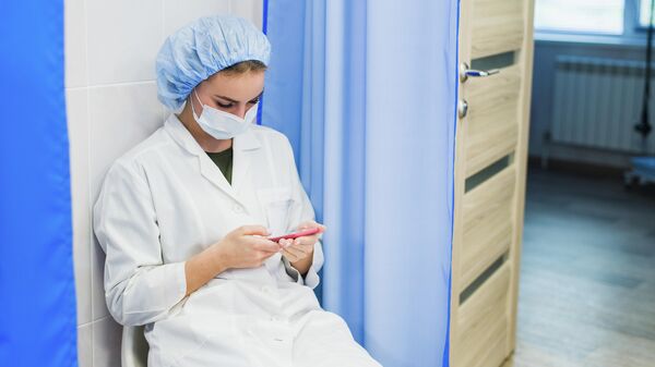 Медсестра с мобильным телефоном во время перерыва.  Иллюстративная фотография