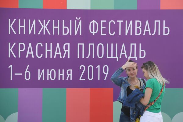 Посетительницы книжного фестиваля на Красной площади в Москве Посетительницы книжного фестиваля на Красной площади в Москве