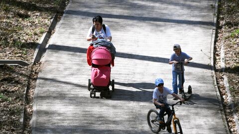 Женщина гуляет с детьми в парке Женщина гуляет с детьми в парке