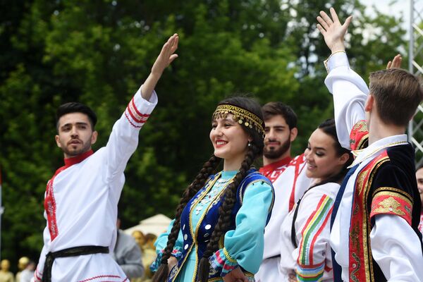 Молодые люди в национальных костюмах выступают на Дне России в парке им. М. Горького в Казани Молодые люди в национальных костюмах выступают на Дне России в парке им. М. Горького в Казани