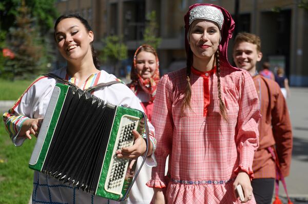 Молодые люди в национальных костюмах на Параде дружбы народов в парке им. М. Горького в Казани Молодые люди в национальных костюмах на Параде дружбы народов в парке им. М. Горького в Казани