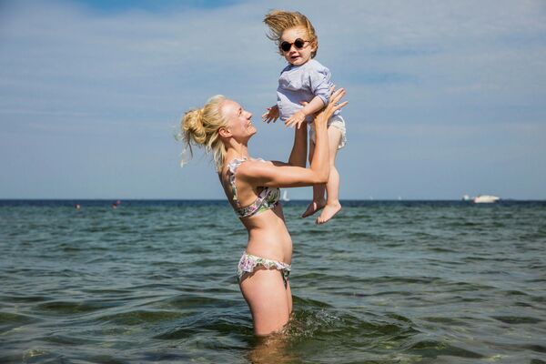 Женщина с ребенком купаются на Амагерском пляже в Копенгагене, Дания