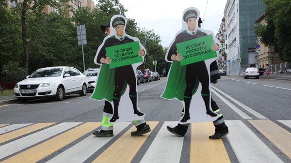Установка предупреждающих фигур для привлечения внимания пешеходов перед нерегулируемым пешеходным переходом в центре Москвы