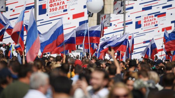 Участники флешмоба в честь Дня государственного флага России на проспекте Сахарова в Москве Участники флешмоба в честь Дня государственного флага России на проспекте Сахарова в Москве