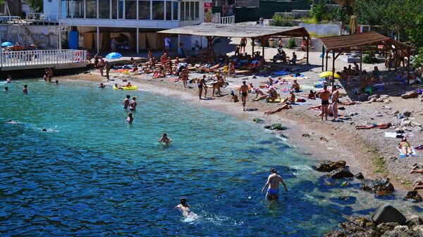 Отдыхающие на пляже Мраморный в поселке Балаклава района Севастополя Отдыхающие на пляже Мраморный в поселке Балаклава района Севастополя