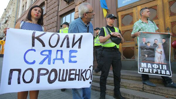 Участники акции против экс-президента Украины Петра Порошенко стоят с плакатами у здания Государственного бюро расследований Участники акции против экс-президента Украины Петра Порошенко стоят с плакатами у здания Государственного бюро расследований