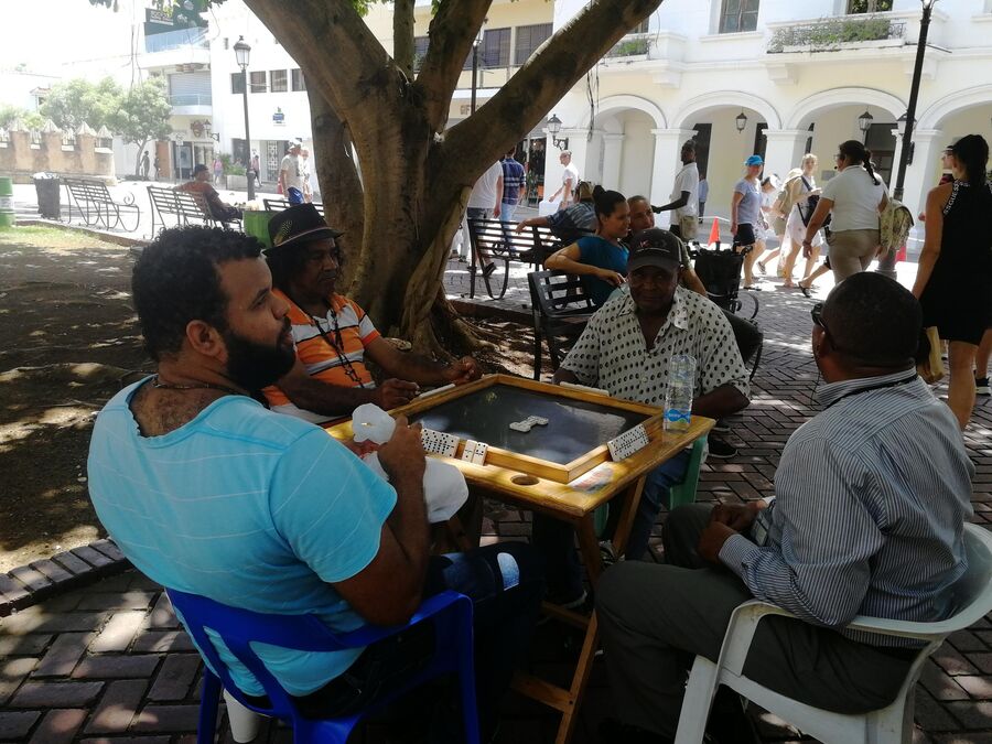 Доминиканцы играют в домино на главной площади Санто-Доминго Парк Колон
