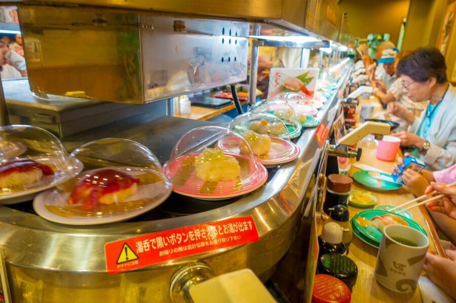Посетители конвейерного суши-ресторана. Токио, Япония