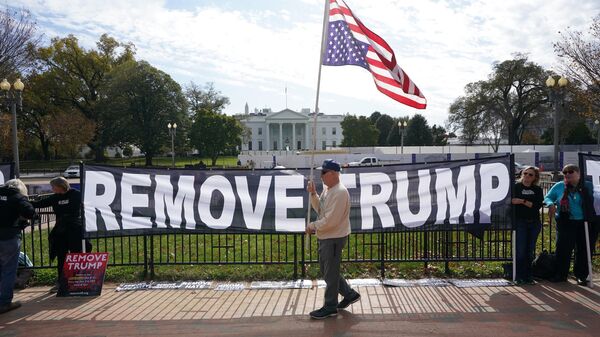 Активисты держат плакат с просьбой об импичменте президента США Дональда Трампа Активисты держат плакат с просьбой об импичменте президента США Дональда Трампа