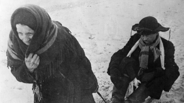 Жители блокадного Ленинграда: женщина везет ослабевшего от голода мужа на санках Жители блокадного Ленинграда: женщина везет ослабевшего от голода мужа на санках