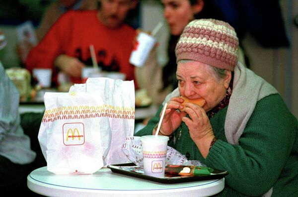 Женщина ест гамбургер в первом Mcdonald's в Москве. 31 января 1990 года Женщина ест гамбургер в первом Mcdonald's в Москве. 31 января 1990 года
