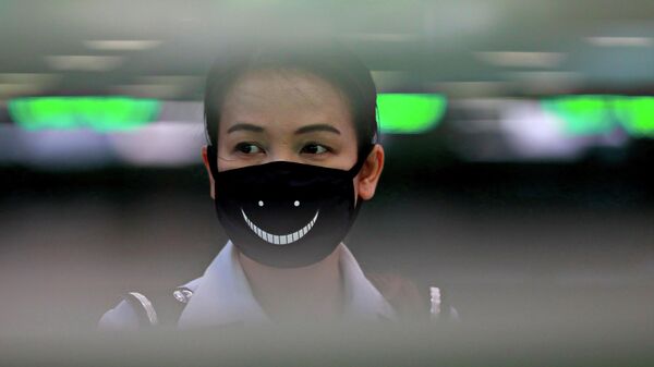 Сотрудница аэропорта Суварнабхуми в защитной маске в Бангкоке